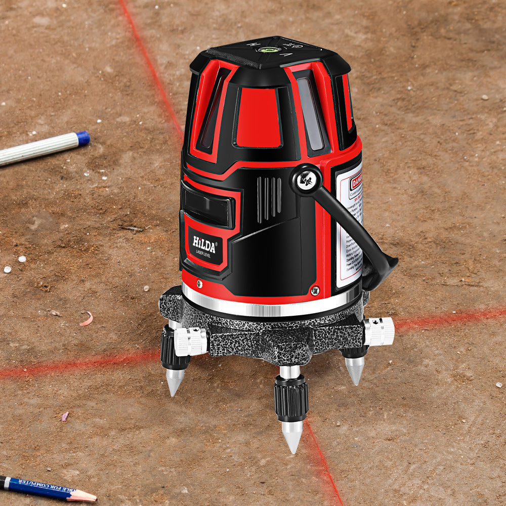 Red and black laser level on a concrete floor with red laser lines.