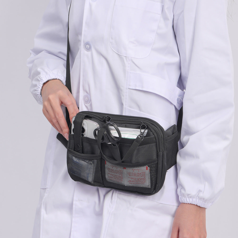Person wearing a black waist bag with compartments on a plain background